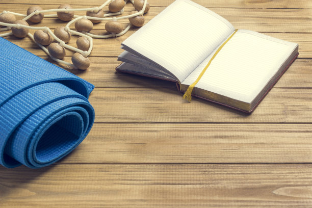 笔记本上的笔，蓝色的训练垫和木制脚轮的按摩器。图片下载