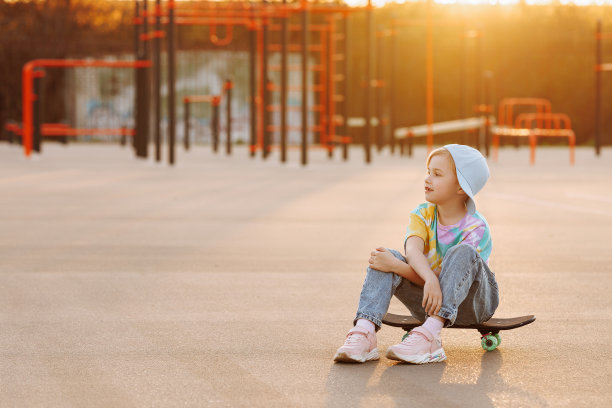 溜冰的小孩或女孩坐在滑板上。图片下载