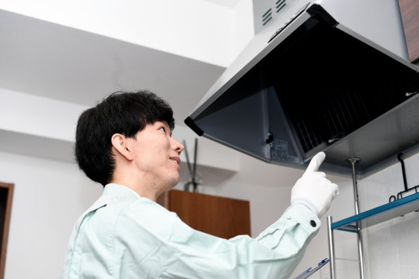 亚洲男工人检查通风机(抽油烟机)图片下载