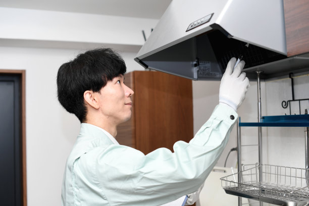 亚洲男工人检查通风机(抽油烟机)图片下载