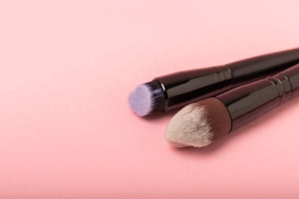 化妆用的化妆品。化妆刷在粉红色的背景上。创意时尚理念。化妆刷的集合，俯视图，横幅。平的。图片下载