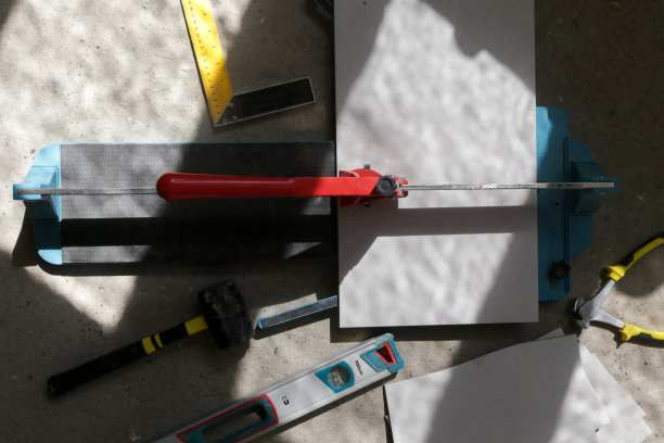 使用标准的手动瓷砖切割机切割瓷砖。瓷砖在浴室中逐步安装的过程。DIY家居装修。图片下载