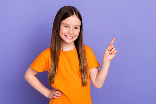 年轻的学校孩子的照片，女孩指着手指选择最喜欢的业余爱好课程的技能发展模型孤立的紫色背景图片下载