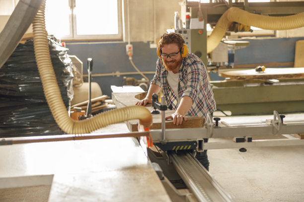 男木匠在木工车间用圆锯锯木板。高质量照片图片下载