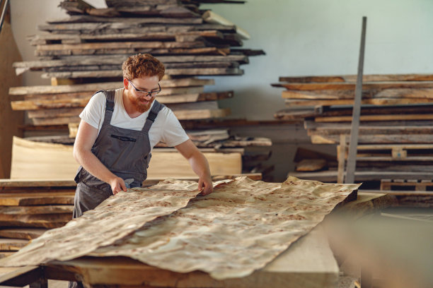 木工在木工车间测量木材。高质量照片图片下载