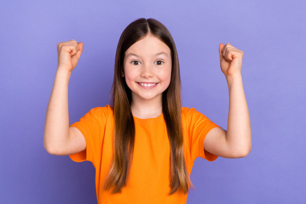 照片有趣的庆祝学校的孩子女孩举起拳头冠军成就目标可怕的胜利孤立在紫色的背景图片下载