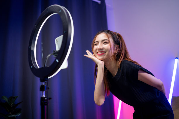 年轻的时尚影响者亚洲女人在家里的客厅里用霓虹灯跳舞。创作者，视频博主，才艺舞蹈，享受爱好，内容录制，展示视频分享在社交媒体上。图片下载