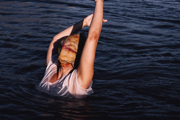 白种人女模特用织物覆盖她的头在海里-创意时尚照片在水中图片下载