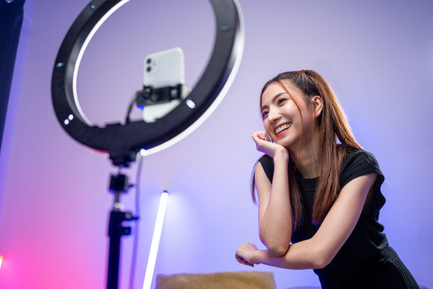 年轻的时尚影响者亚洲女人在家里的客厅里用霓虹灯跳舞。创作者，视频博主，才艺舞蹈，享受爱好，内容录制，展示视频分享在社交媒体上。图片下载