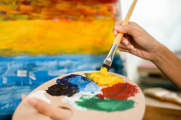 近距离的手亚洲女艺术家正在用画笔和不同的丙烯酸颜料绘画。作为艺术概念的女艺术家在创作工作室的画布上作画图片下载