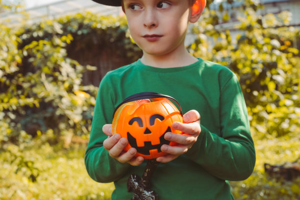 一个男孩的肖像，手里拿着装满糖果的南瓜篮子图片下载