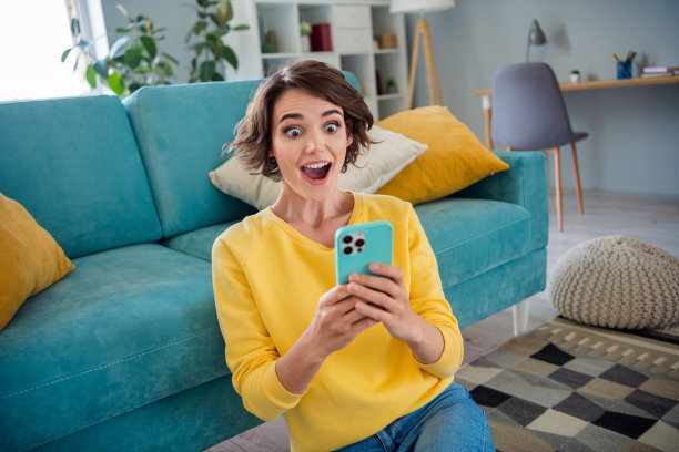 印象深刻的震惊女士的照片说视频意想不到的令人难以置信的反应坐在地板地毯看着摄像机屏幕在房间里图片下载