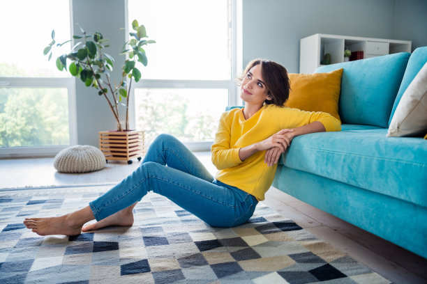聪明可爱的漂亮女孩坐在现代酒店房间的地板上思考梦想的照片图片下载