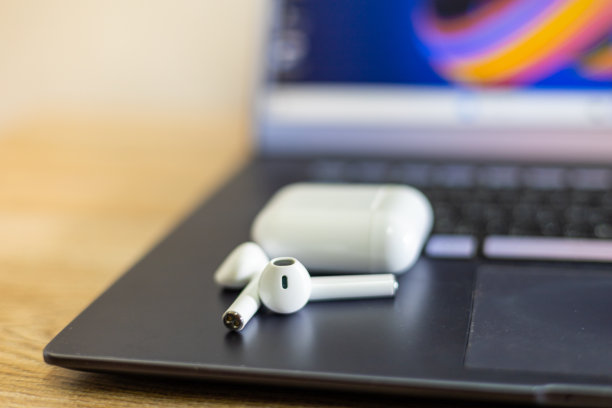 电脑上的白色无线耳机，背景模糊图片下载