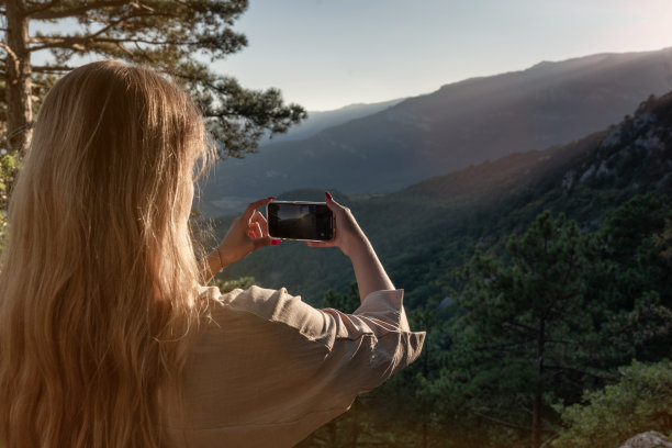 美丽的年轻女子在大自然中沉思，在一个美丽的森林里。旅行和健康的生活方式，享受自由和自然。图片下载