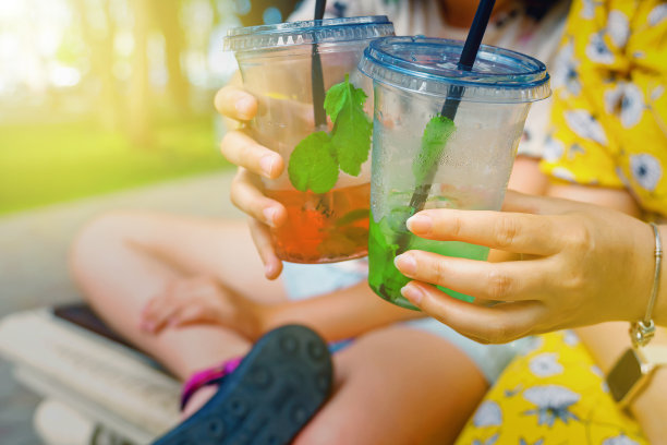 手里拿着杯子，杯子里盛着莫吉托和西瓜柠檬水图片下载