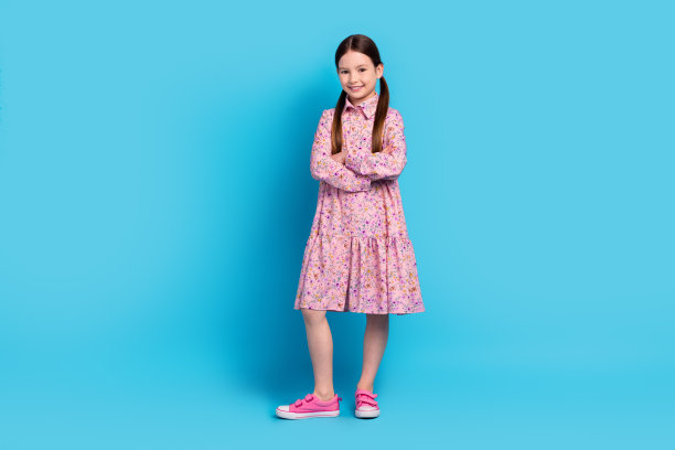 幸福的年轻女孩的全身长度照片折叠手臂粉红色时尚运动鞋自信的模特孩子孤立的蓝色背景图片下载