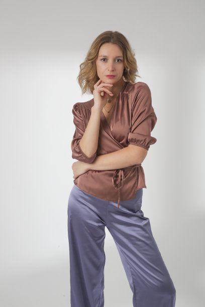 一系列的工作室照片，年轻的女模特穿着简单漂亮的衣服，丝绸缎棕色衬衫和淡紫色阔腿裤图片下载