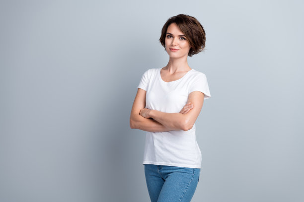 照片中可爱漂亮的女士穿着白色t恤双臂折叠，空白空间孤立灰色背景图片下载