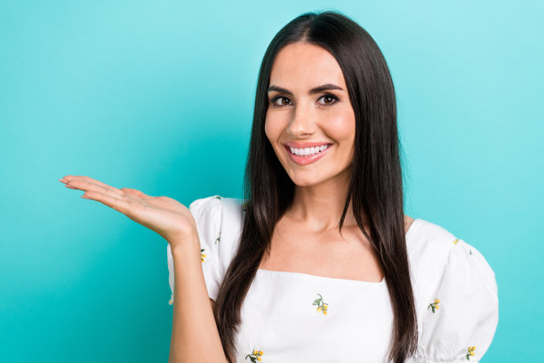 年轻女士的特写照片，穿着时尚的夏季白色连衣裙，手持掌上便宜的产品秘密盒子新奇孤立的蓝色背景图片下载