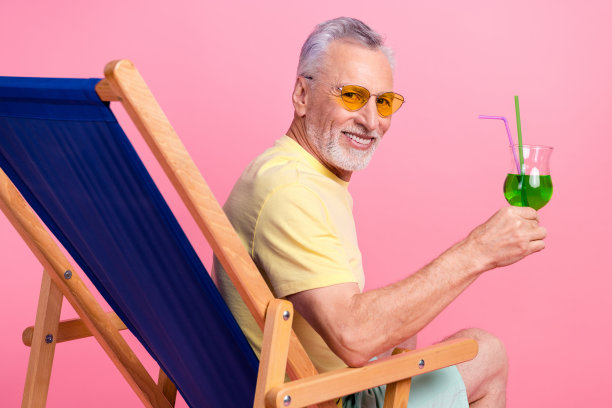友好的高级商人的特写照片放松酒精绿色美味的鸡尾酒欢呼日光浴孤立在粉红色的背景图片下载