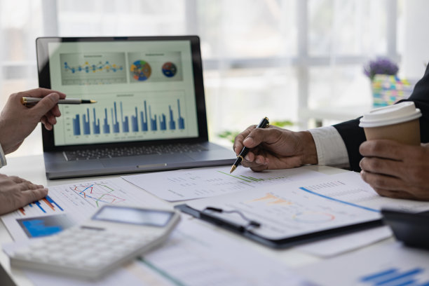 商务人士在办公室开会商务人士和办公室职员在开会，会议桌上放着项目规划文件。特写照片图片下载