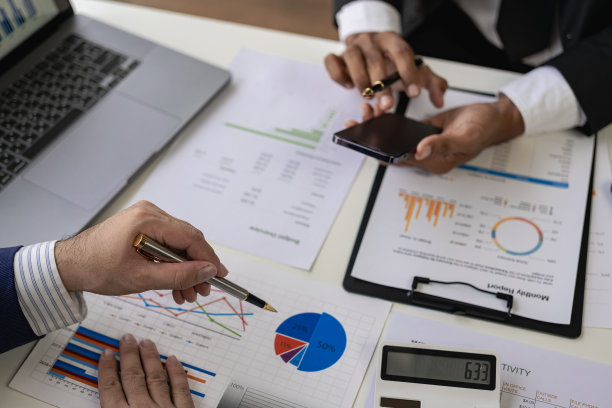 商务人士在办公室开会商务人士和办公室职员在开会，会议桌上放着项目规划文件。特写照片图片下载