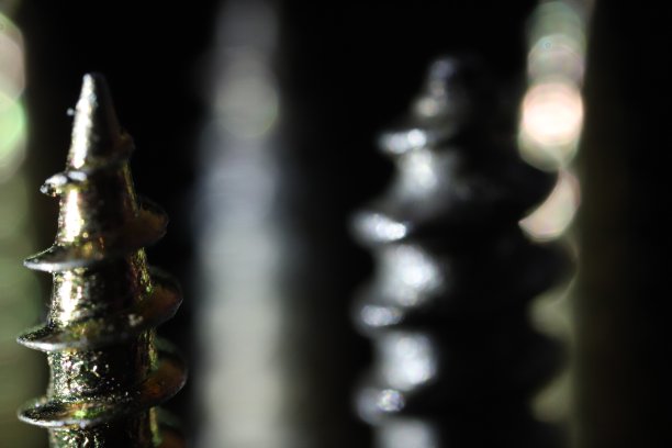 黑色背景上螺丝的特写细节。黑暗的壁纸。图片下载