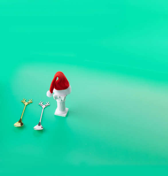 圣诞老人的帽子在绿色背景上的白色柱子上。图片下载