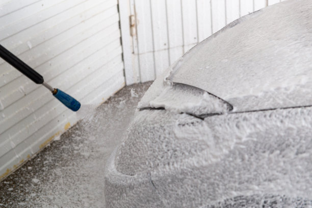 将白色加压的非接触泡沫涂在洗车用的汽车上的过程图片下载