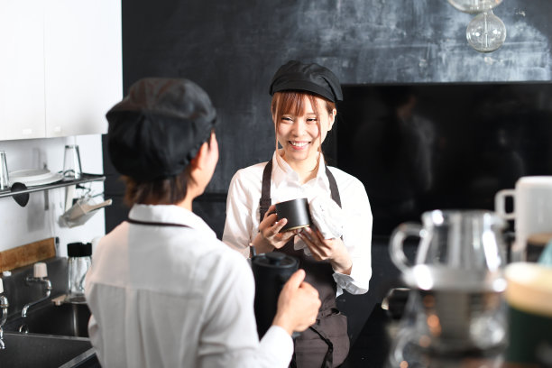 年轻的亚洲妇女微笑着，愉快地在餐厅厨房工作图片下载