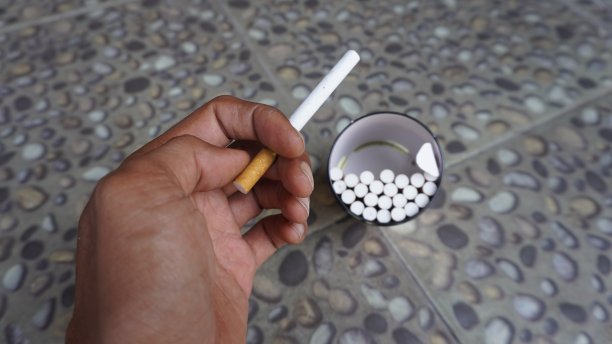 从上面看，手拿着装满许多香烟的香烟罐。香烟锡图片下载