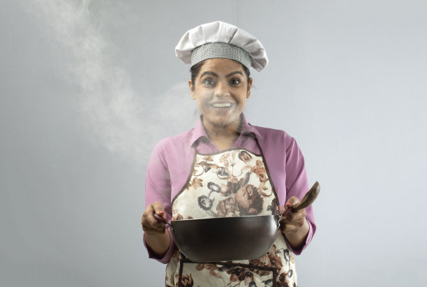 兴奋的女厨师拿着白色背景的平底锅图片下载