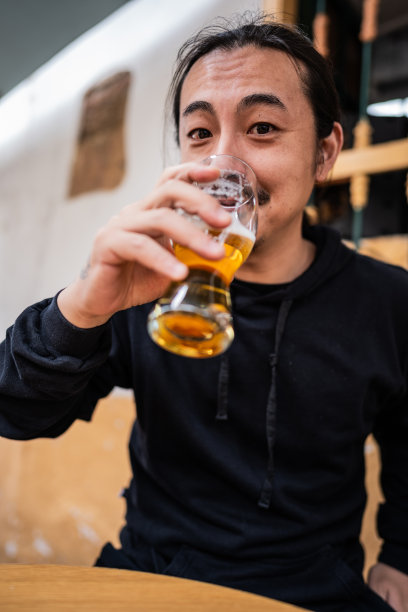 一个成熟的亚洲男人在餐厅喝啤酒的照片图片下载