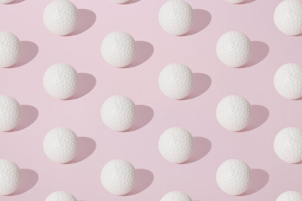 白色高尔夫球排列在粉色粉彩背景上。模式。图片下载