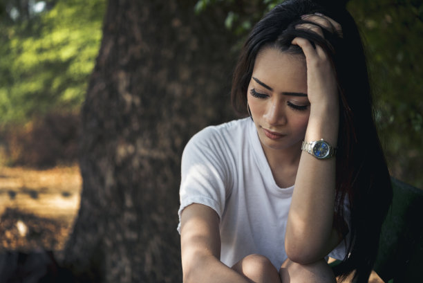 在绿色公园的户外办公室里，使用笔记本电脑的女性努力工作。年轻女性有头痛，沮丧，从失败的事业倦怠。疲惫的亚洲女人绝望悲伤的问题图片下载