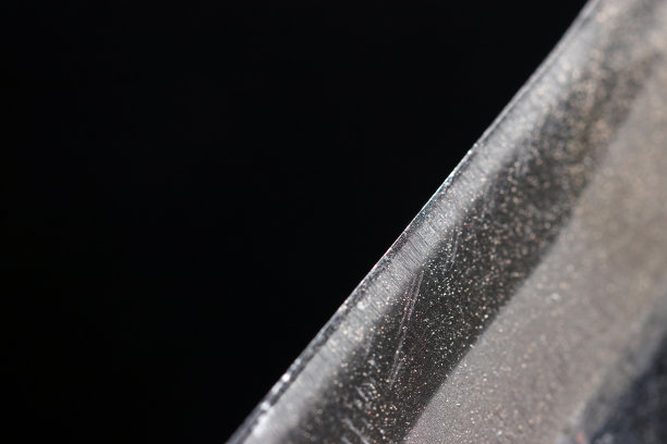 近景:一把日本斧头的刀刃，带有美丽的钢铁图案((黑色背景，特写微距照片)图片下载