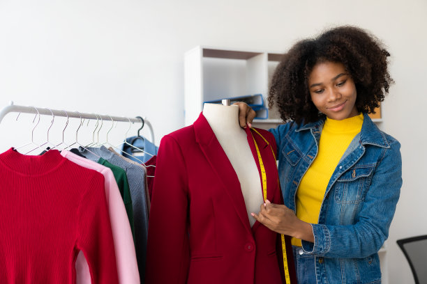 非裔美国女孩在网上通过直播赠送和销售服装，选择一家时尚的服装店。时装设计师绘制新系列的图片。图片下载