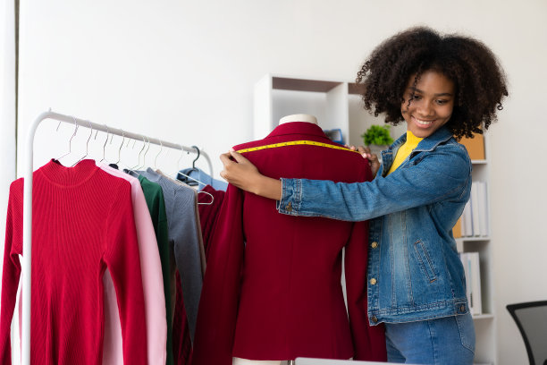 非裔美国女孩在网上通过直播赠送和销售服装，选择一家时尚的服装店。时装设计师绘制新系列的图片。图片下载