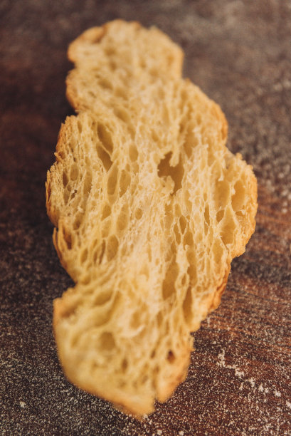 一张乡村木桌上刚烤好的牛角面包的半截垂直照片图片下载