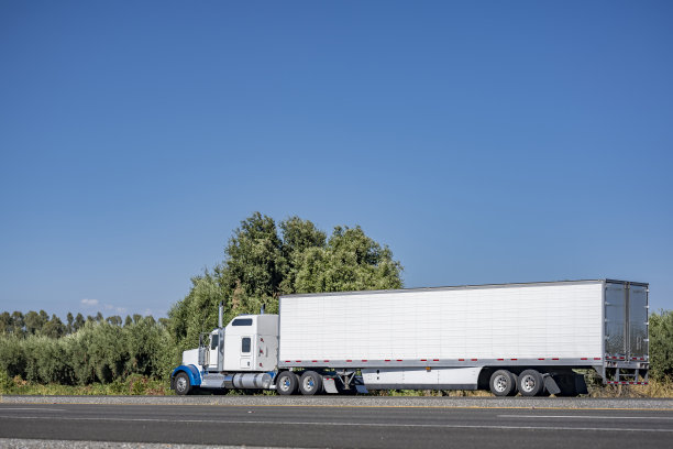 强大的白色经典大井盖半挂车运输货物冷藏半挂车在路上移动，及时交货图片下载