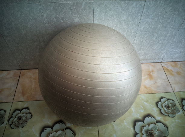 一个球坐在瓷砖地板上。漂亮的球的照片。图片下载