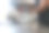 一名男工人戴着蓝色手套，在金属台上用切片机切火腿。图片下载
