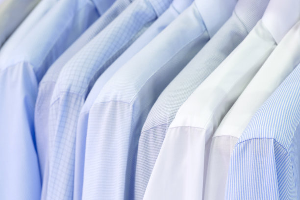 男士衬衫悬挂的特写照片。衣服挂在架子上。衣架与衬衫。男士职业装图片下载