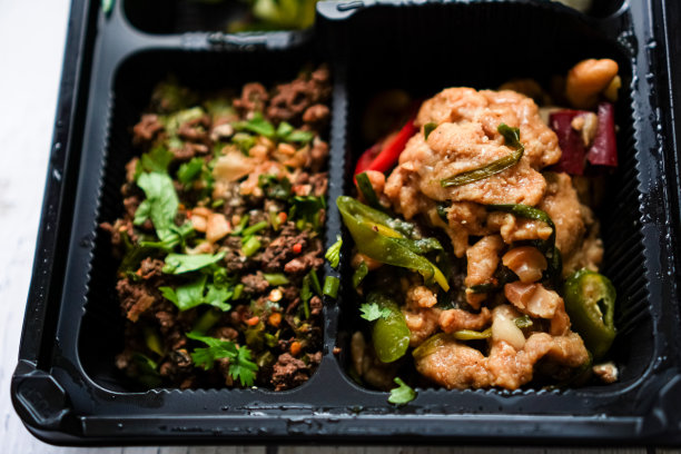 麻辣肉末沙拉和泰式腰果鸡的餐盒菜单的特写照片。图片下载