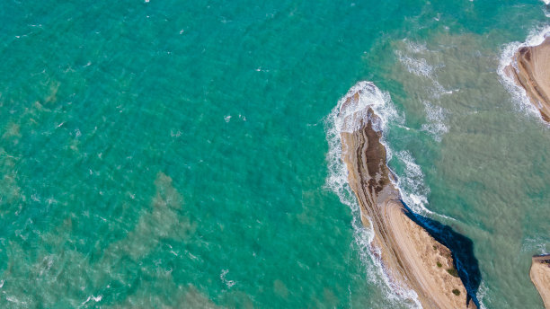 从上面看蓝绿色的水和岩石。无人机航拍照片。平静的照片，大海背景与空间的铭文。图片下载