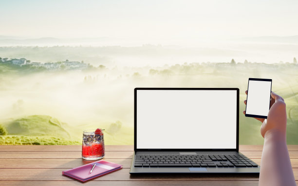 电脑、笔记本和智能手机，长长的木桌上的白色屏幕。自然背景。山。雾蒙蒙的。早....在线工作，户外自由职业者。3 d渲染。图片下载