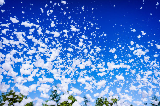 背景是白色的肥皂泡飞过蓝天。图片下载