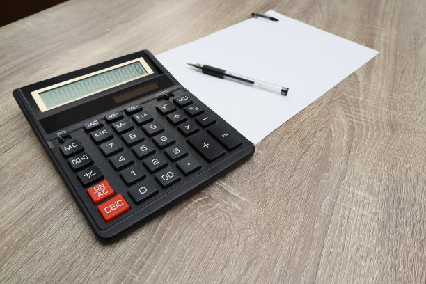 计算器、铅笔和白纸放在木桌上。计算概念选择焦点图片下载