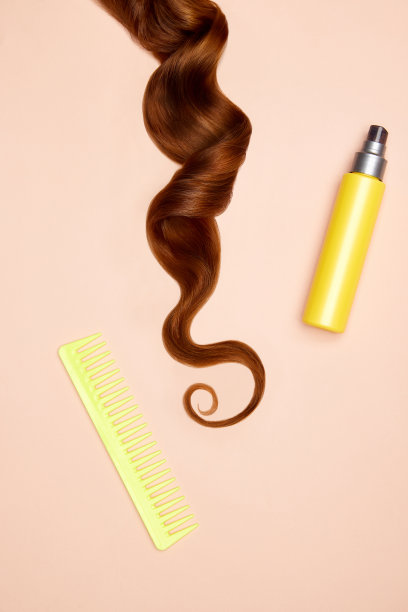 波浪长黑发的照片，喷雾，梳在柔和的背景。俯视图，平铺。副本的空间。自我护理，头发护理。图片下载